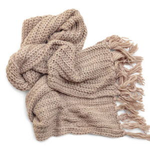 Beige woolen knitted scarf with tassels on white background, top view.